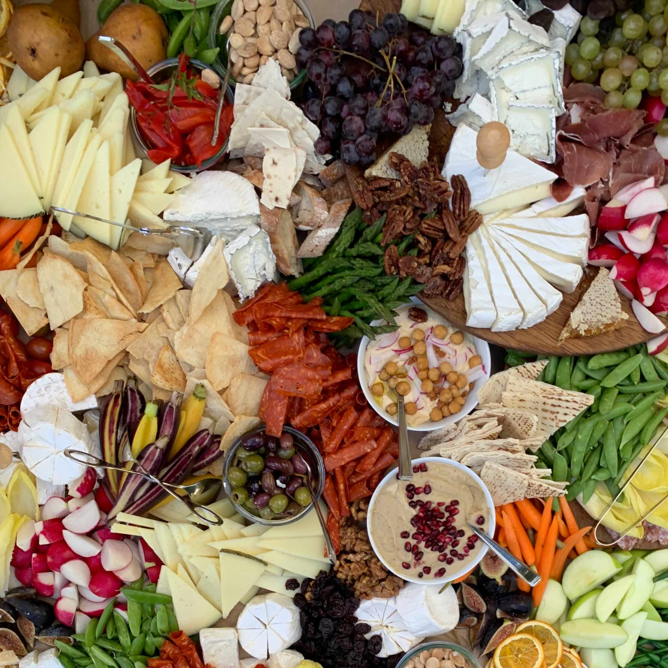 A serving plate featuring a wide variety of cheeses