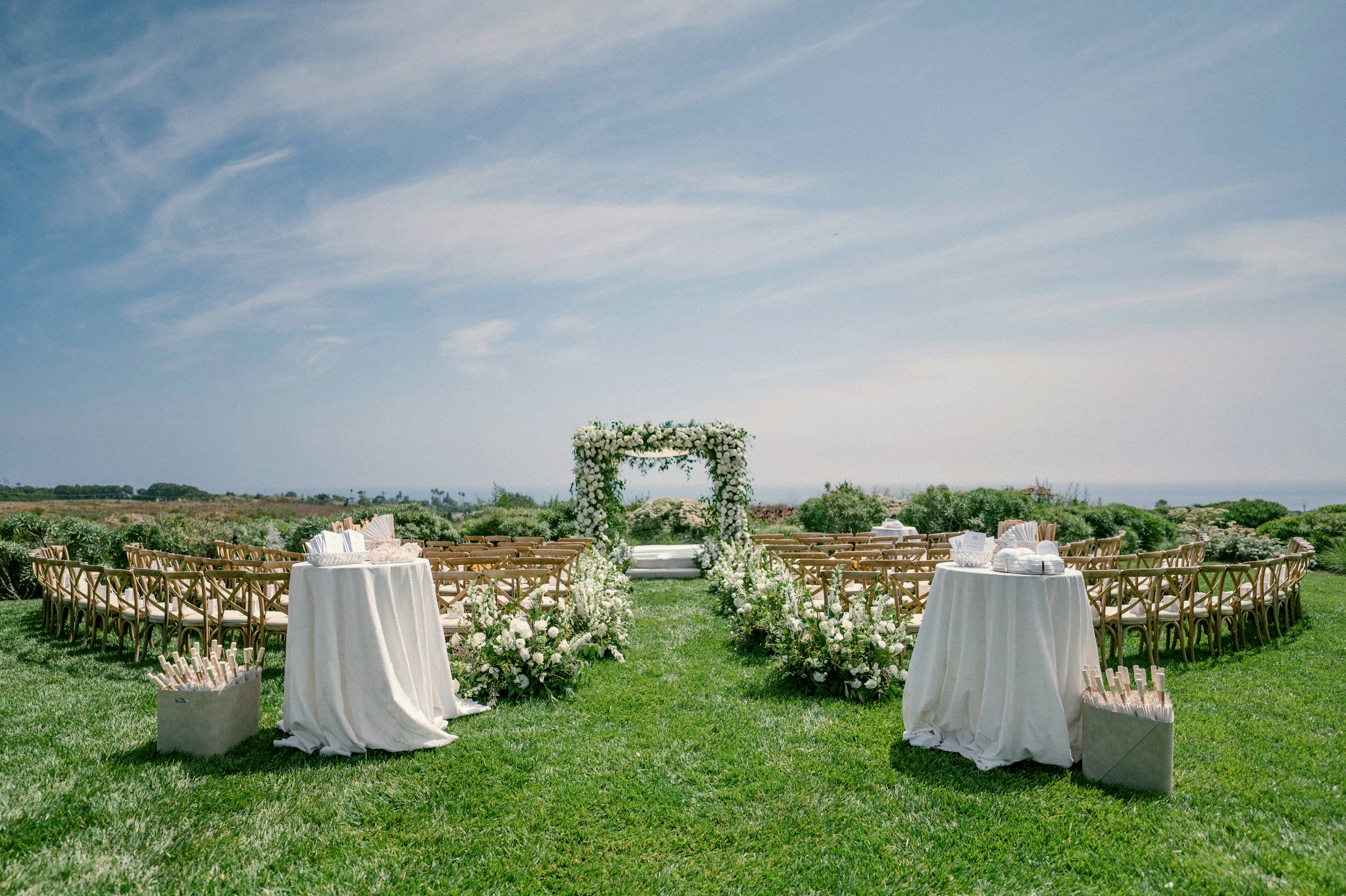 Tables set for a wedding reception outdoors with a blue sky overhead