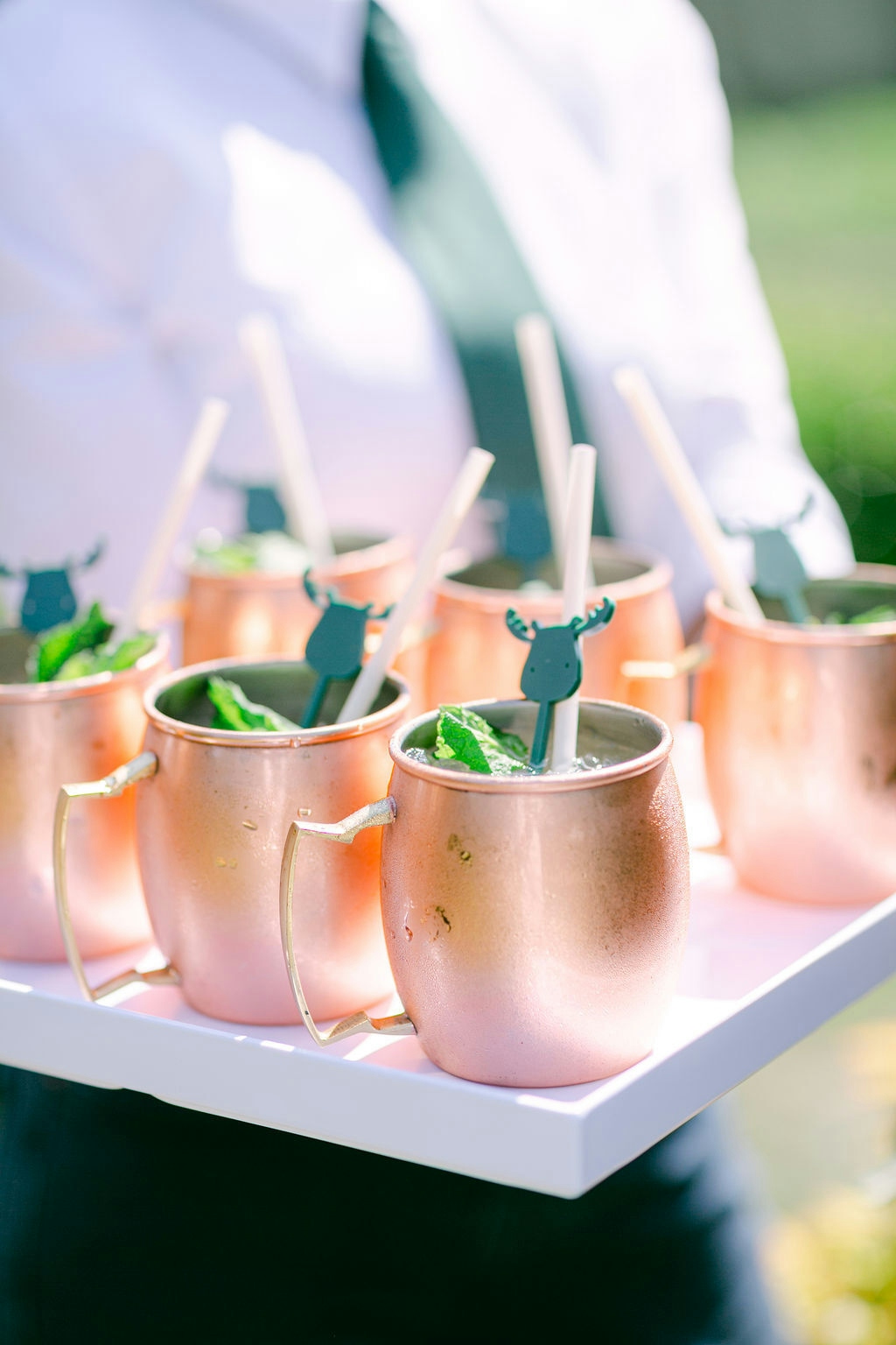 A server holding a tray full of cocktails