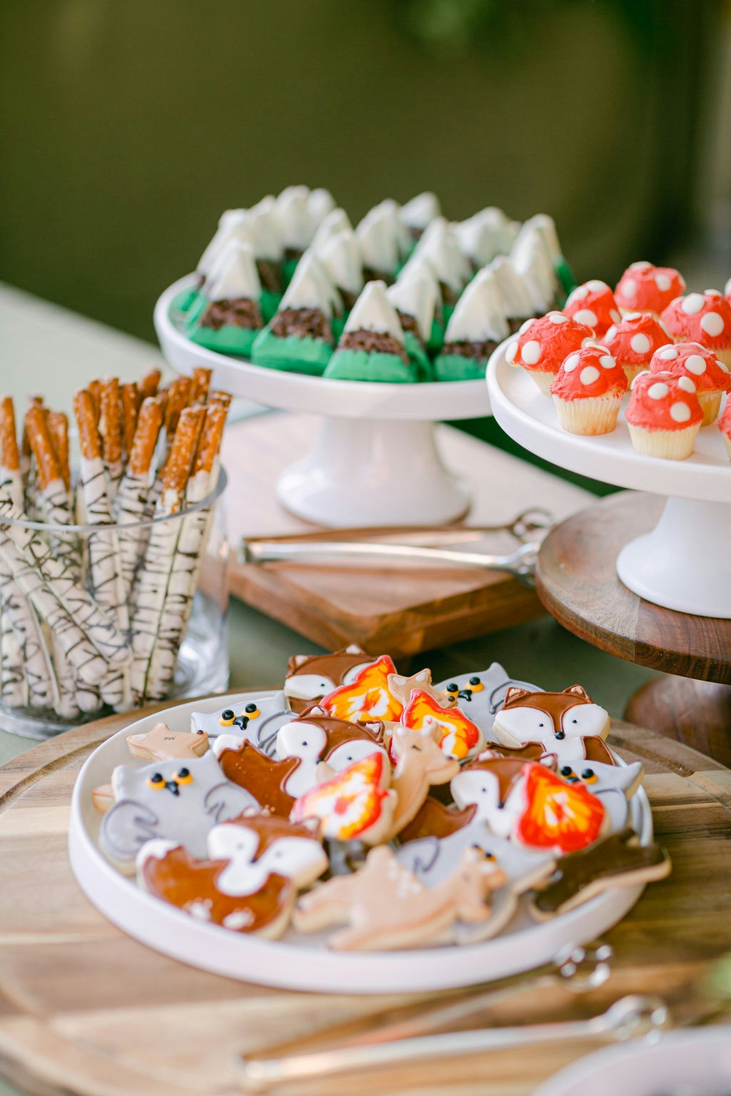 A table with a variety of cookies and pretzels on plates